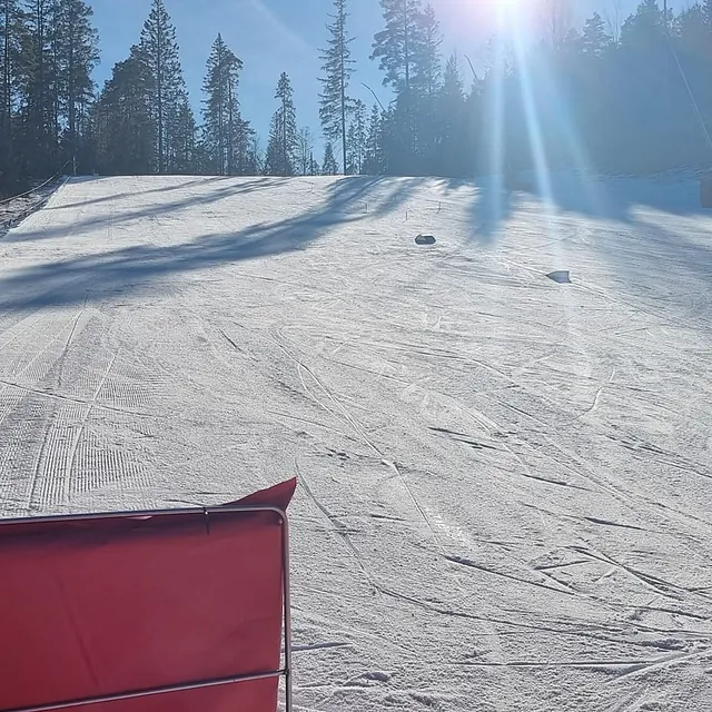 Solbelyst og preparert alpinbakke sett fra tråkkemaskin.